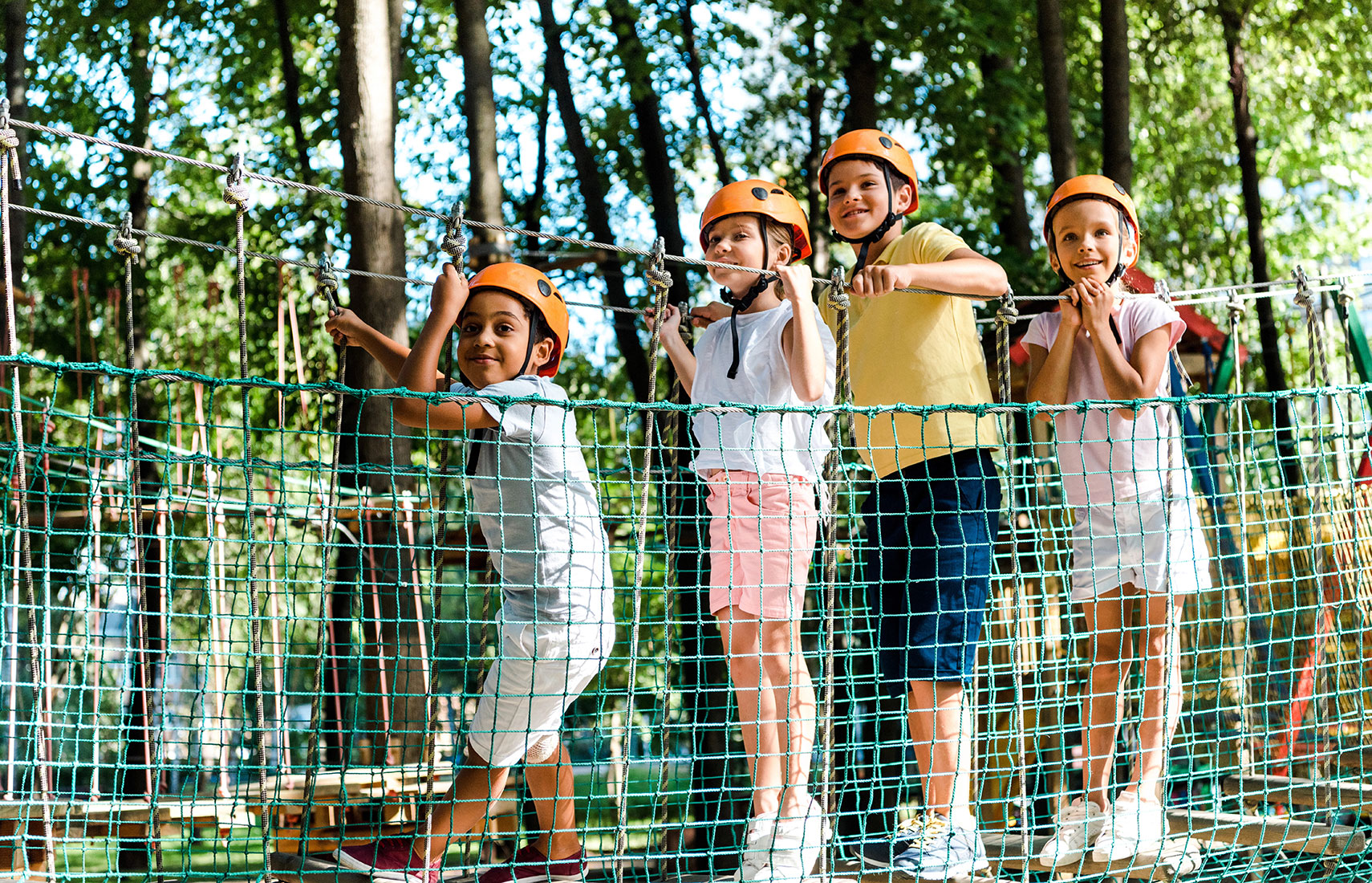 A group of children on a ropes course at a summer camp.