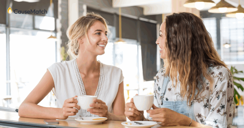 Two women talking over coffee, one asking the other a question