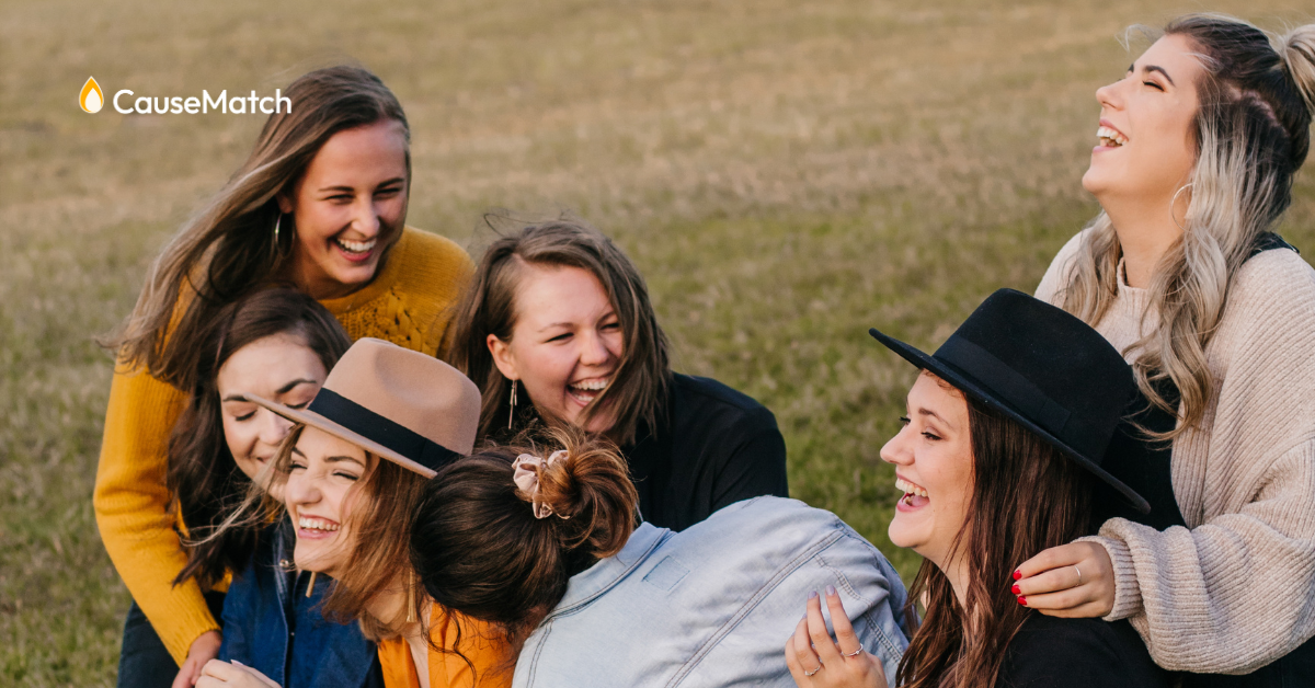 A group of friends laughing in a field.